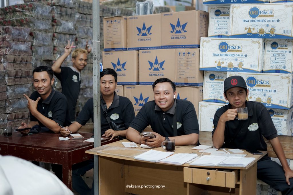 Pemilik toko baru mengecek kualitas kemasan plastik dan strategi pemasaran digital